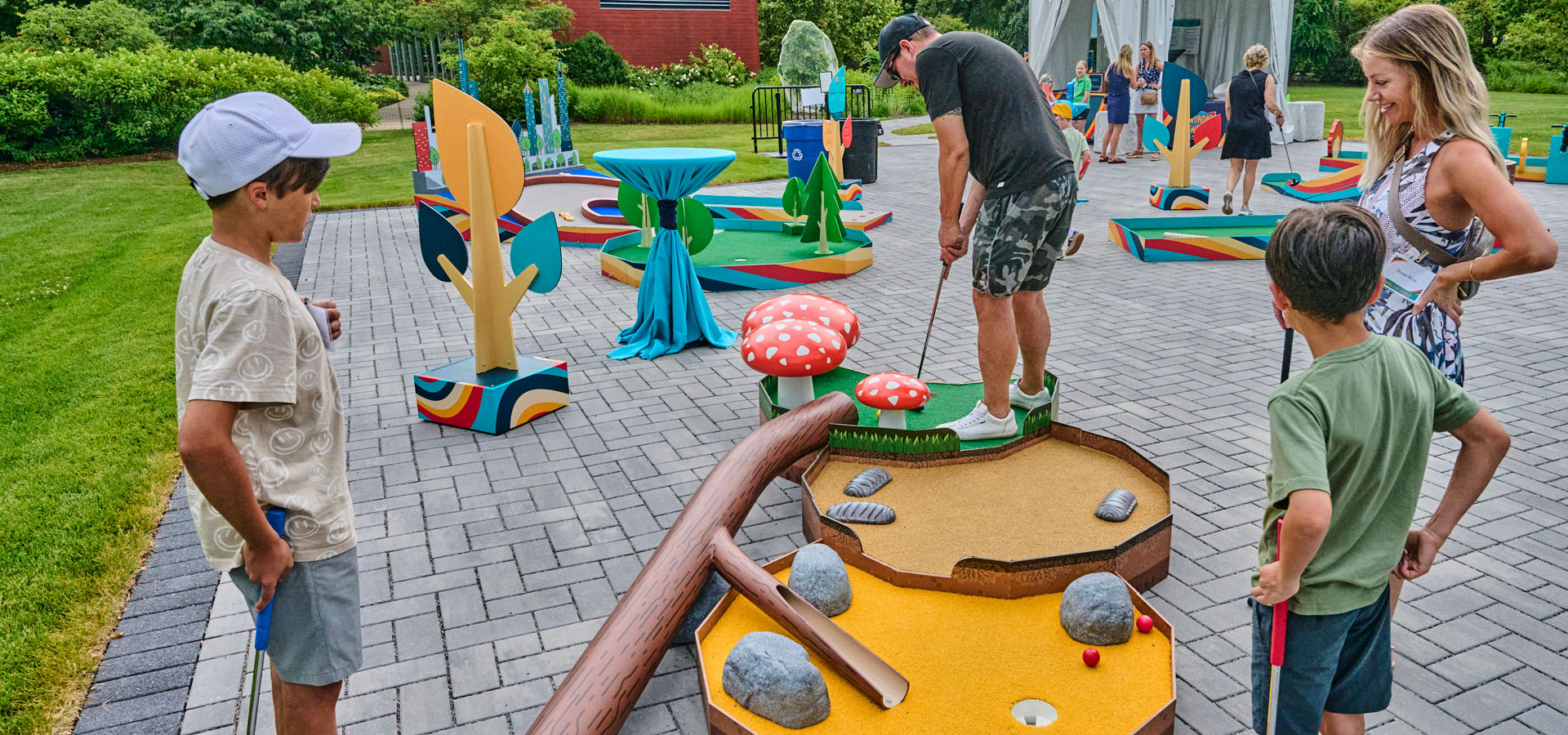 A family plays mini golf at the Swing for Science fundraiser event.