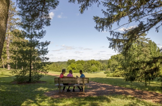 A family rests on a bench at the top of Frost Hill.