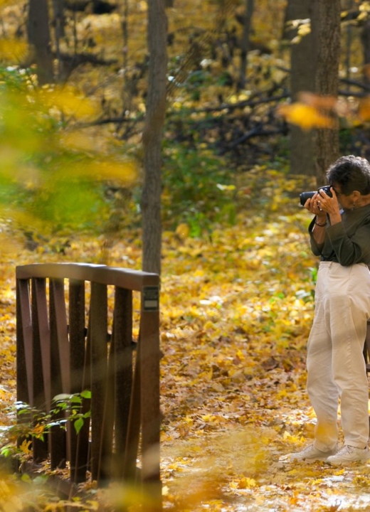 Woman in woods taking a photo
