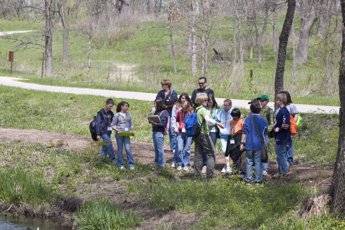 Group of students with a teacher in the woods in spring