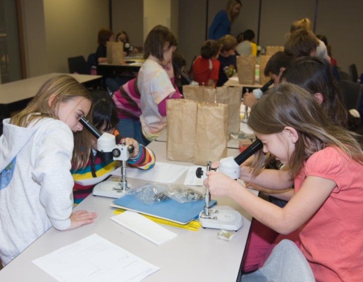 Students using microscopes in a classroom