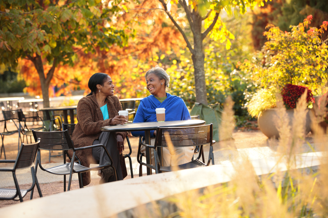 Two women having coffee in the fall in Arbor Court.