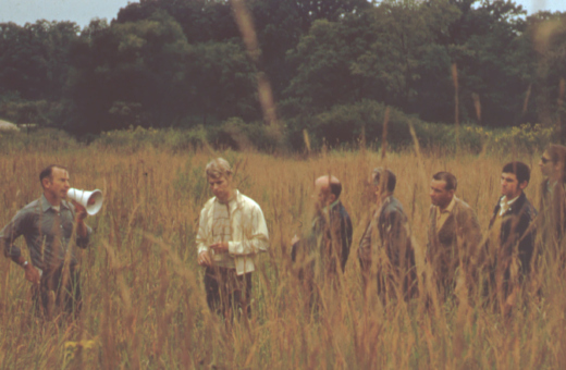 Ray Schulenberg speaking to a group in the prairie