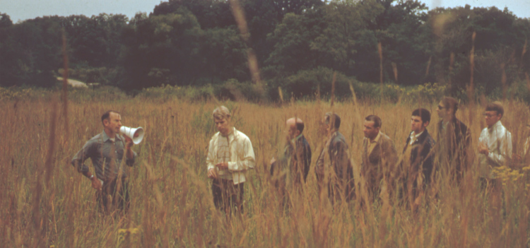 Ray Schulenberg speaking to a group in the prairie