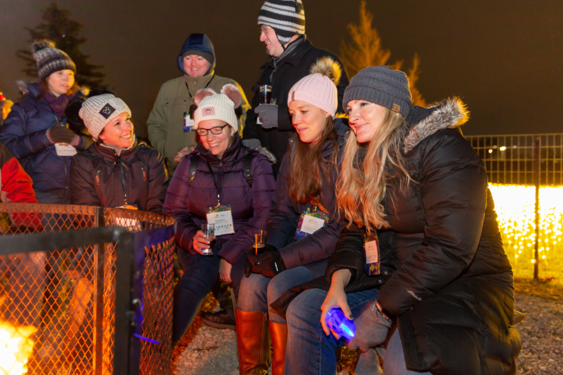 Guests for IllumiBrew gather around a firepit