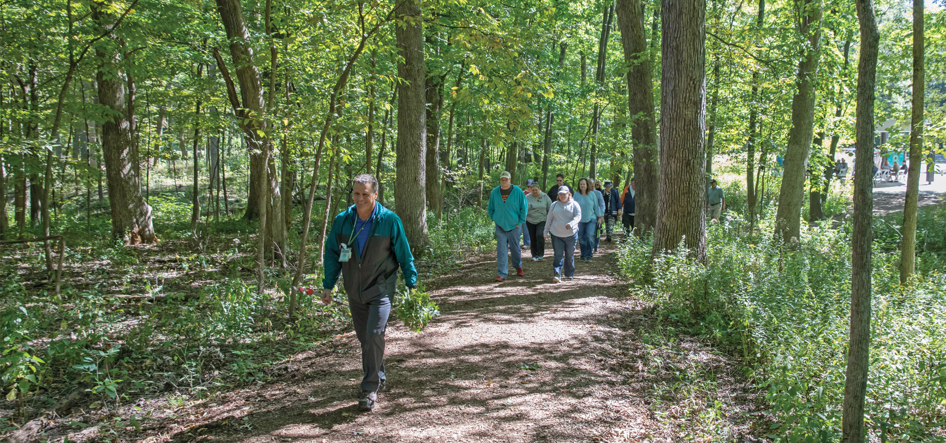 An education class hikes in the woods