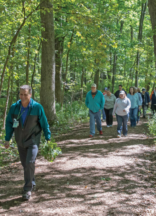 An education class hikes in the woods