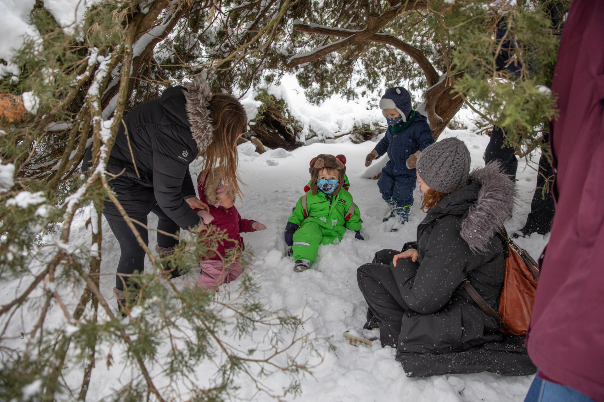 Kids and parents playing in the snow in a winter explorers class.