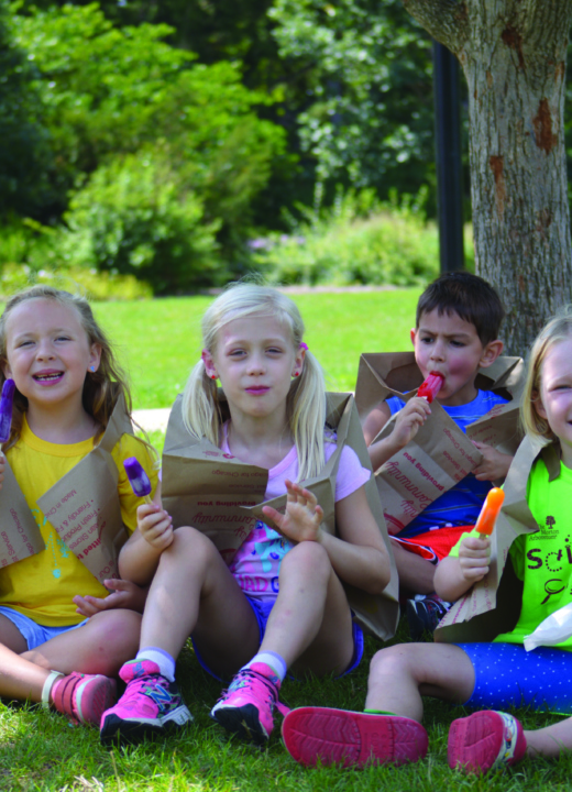 Group of summer science camp kids eats popsicles