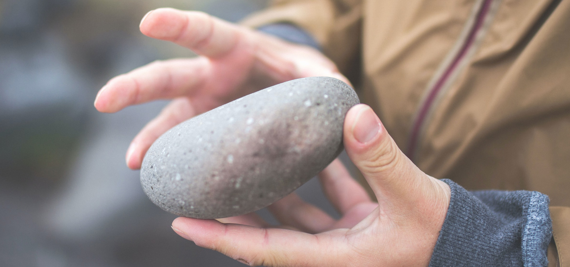 Child holding a rock in their hands