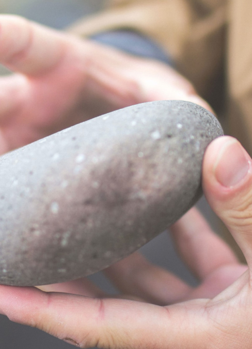 Child holding a rock in their hands
