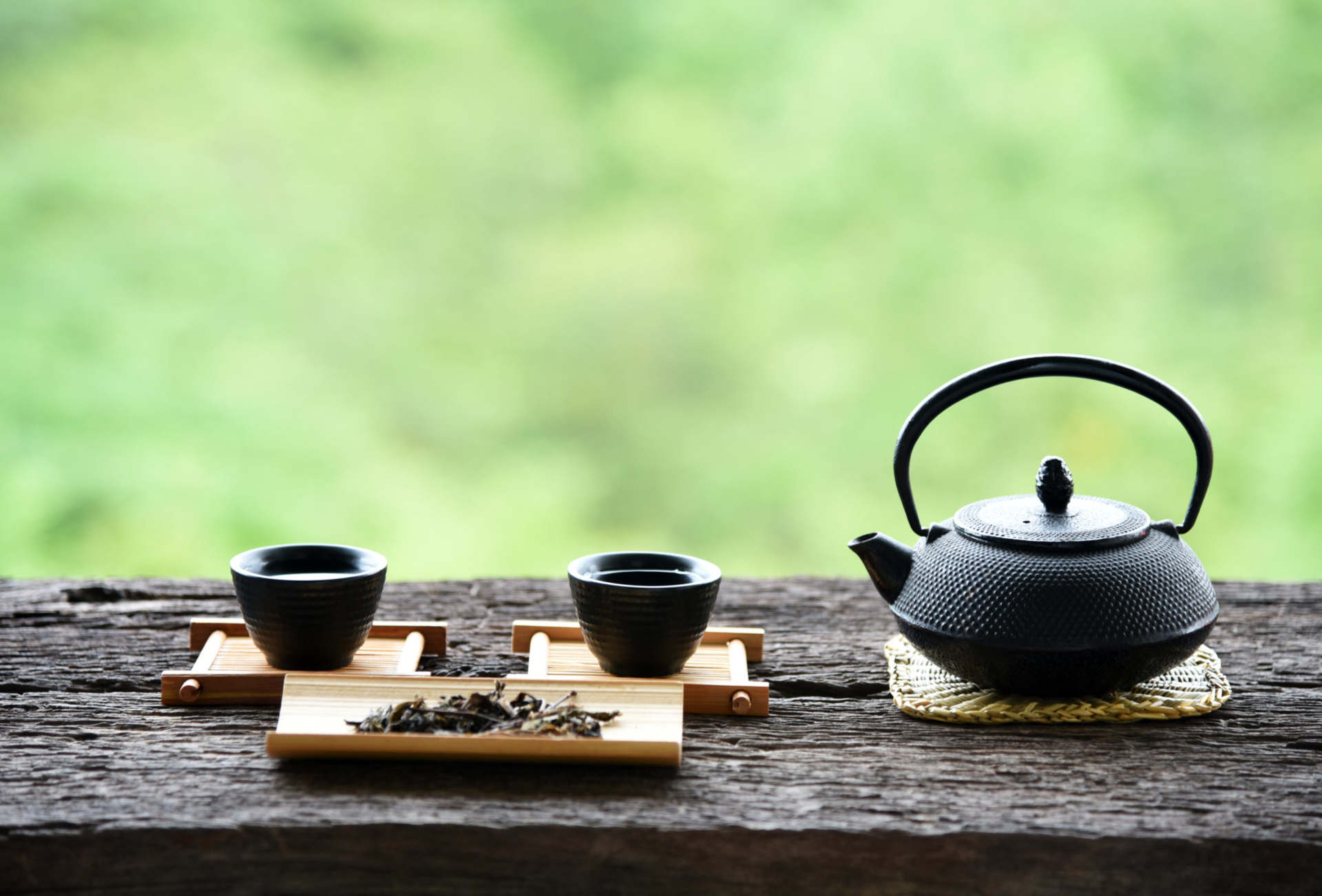 Chinese tea set on a wooden outdoor bench.