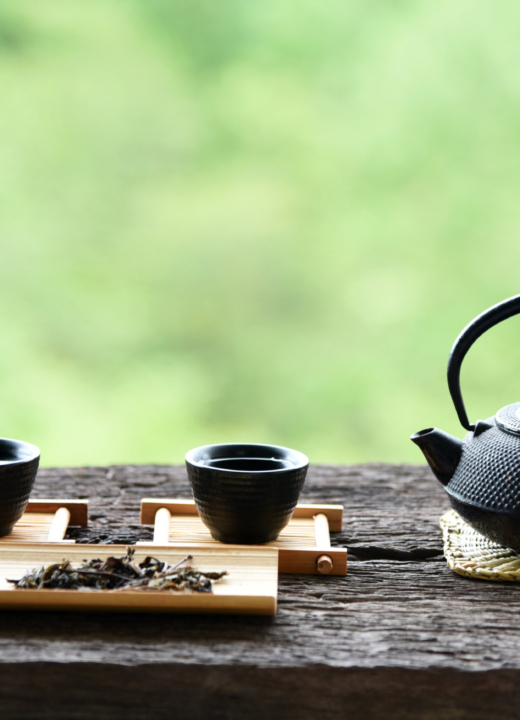Chinese tea set on a wooden outdoor bench.