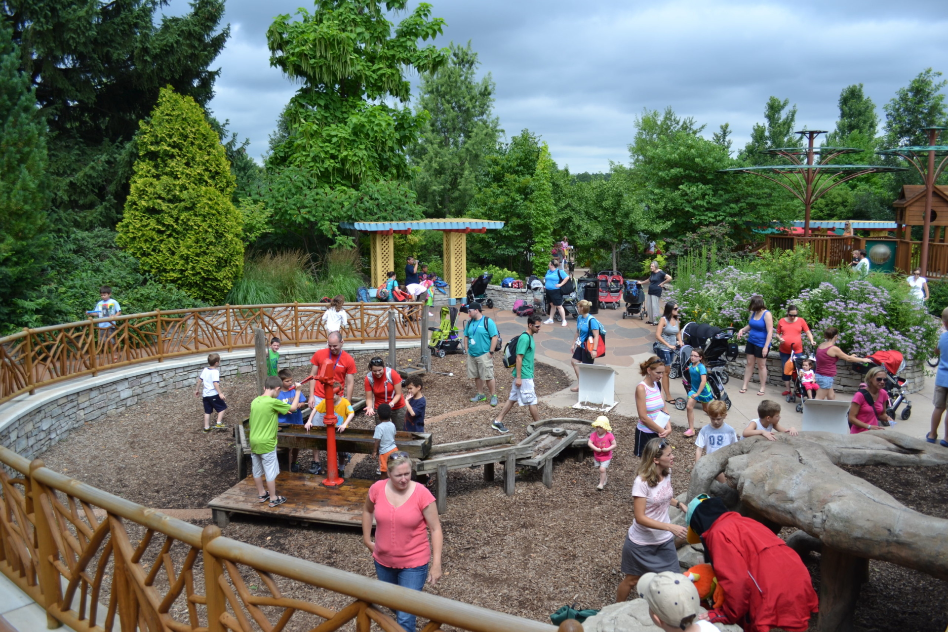 Large group of families and children enjoying the Children's Garden in summer.