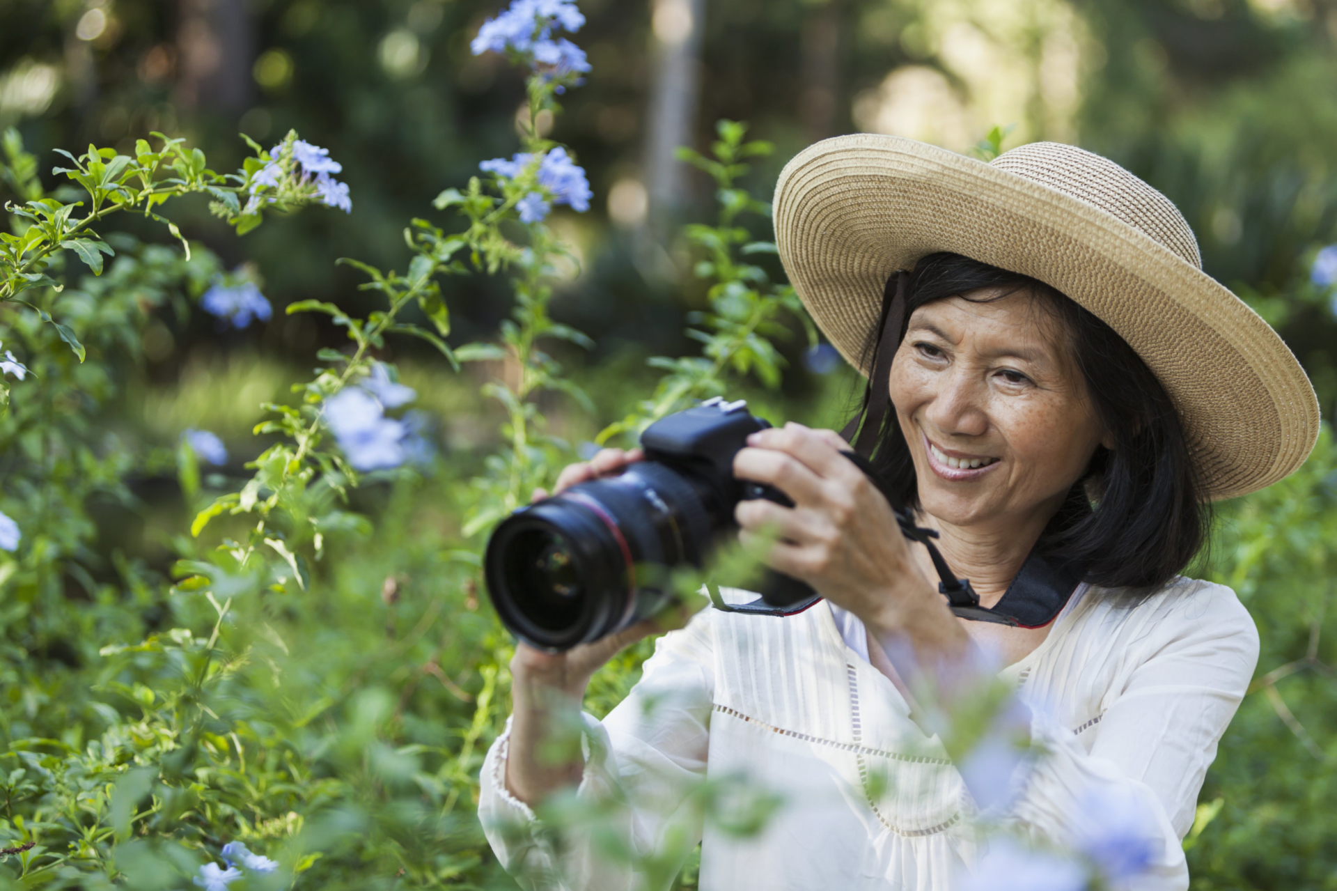 Woman taking photos of flowers outside