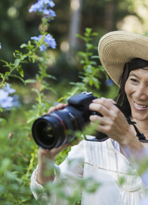 Woman taking photos of flowers outside