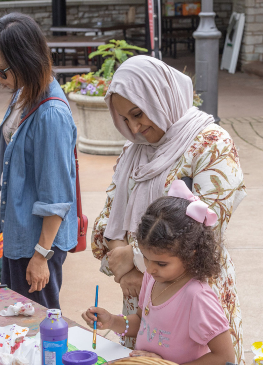 Parents and children create artwork in the children's garden.