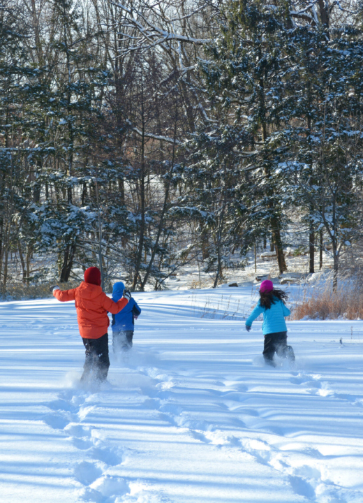 Children running through the snow at an outdoor education program.