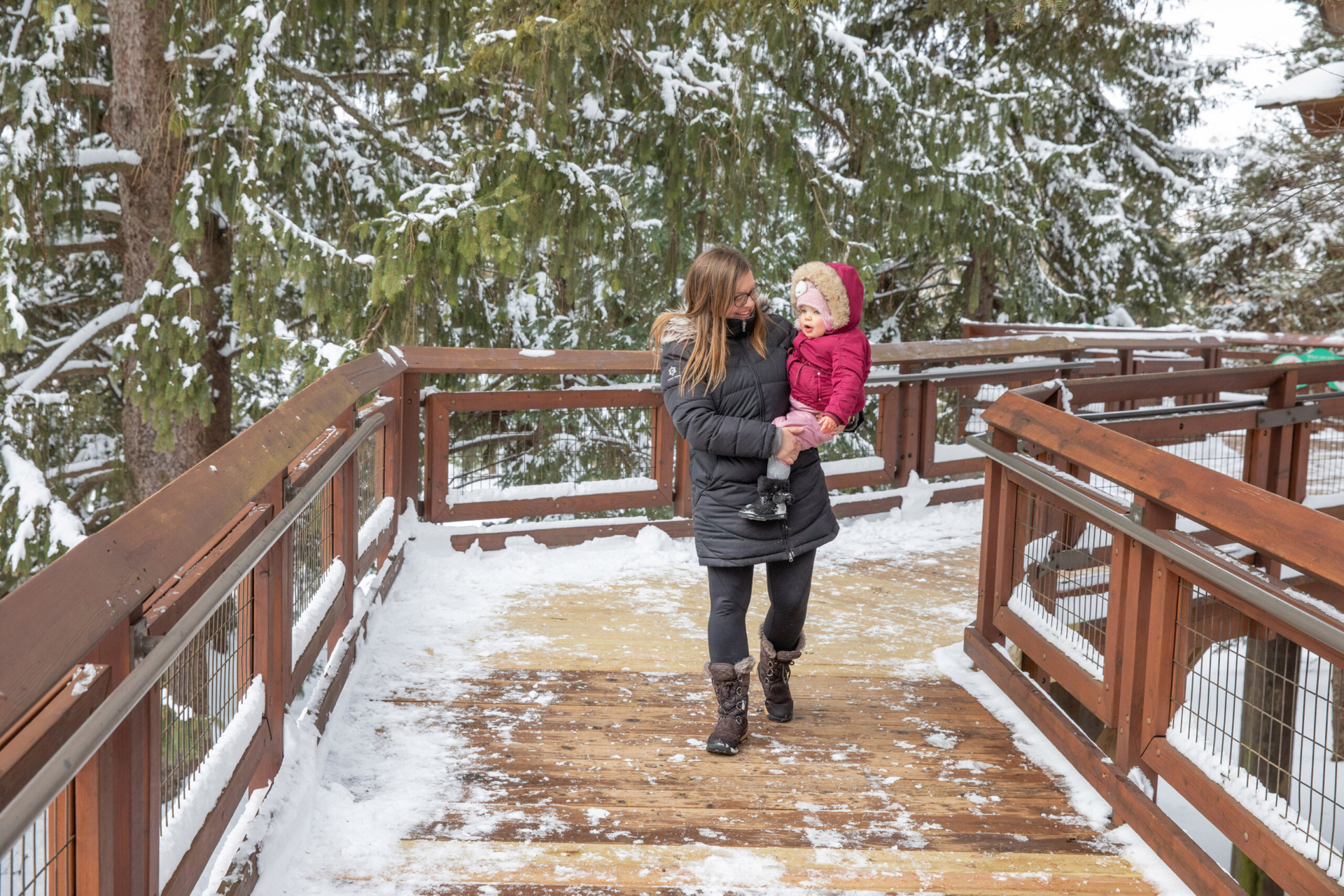 A mother exploring the Children's Garden with her daughter in winter.