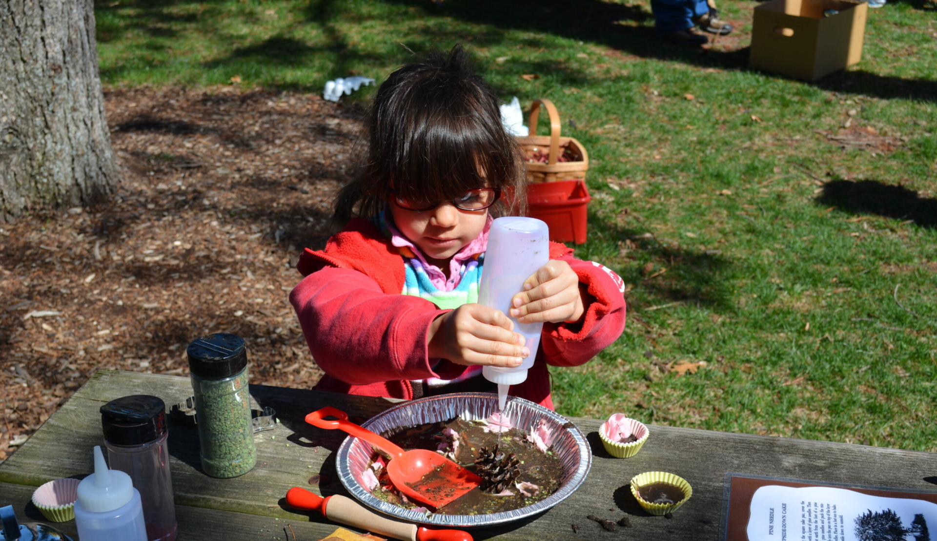 A child making a mud pie on a picnic table.