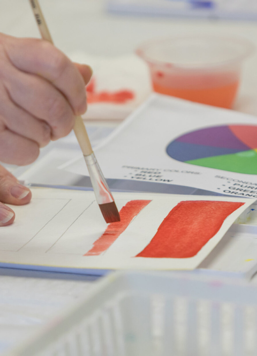 A student working with watercolor paint during a class.