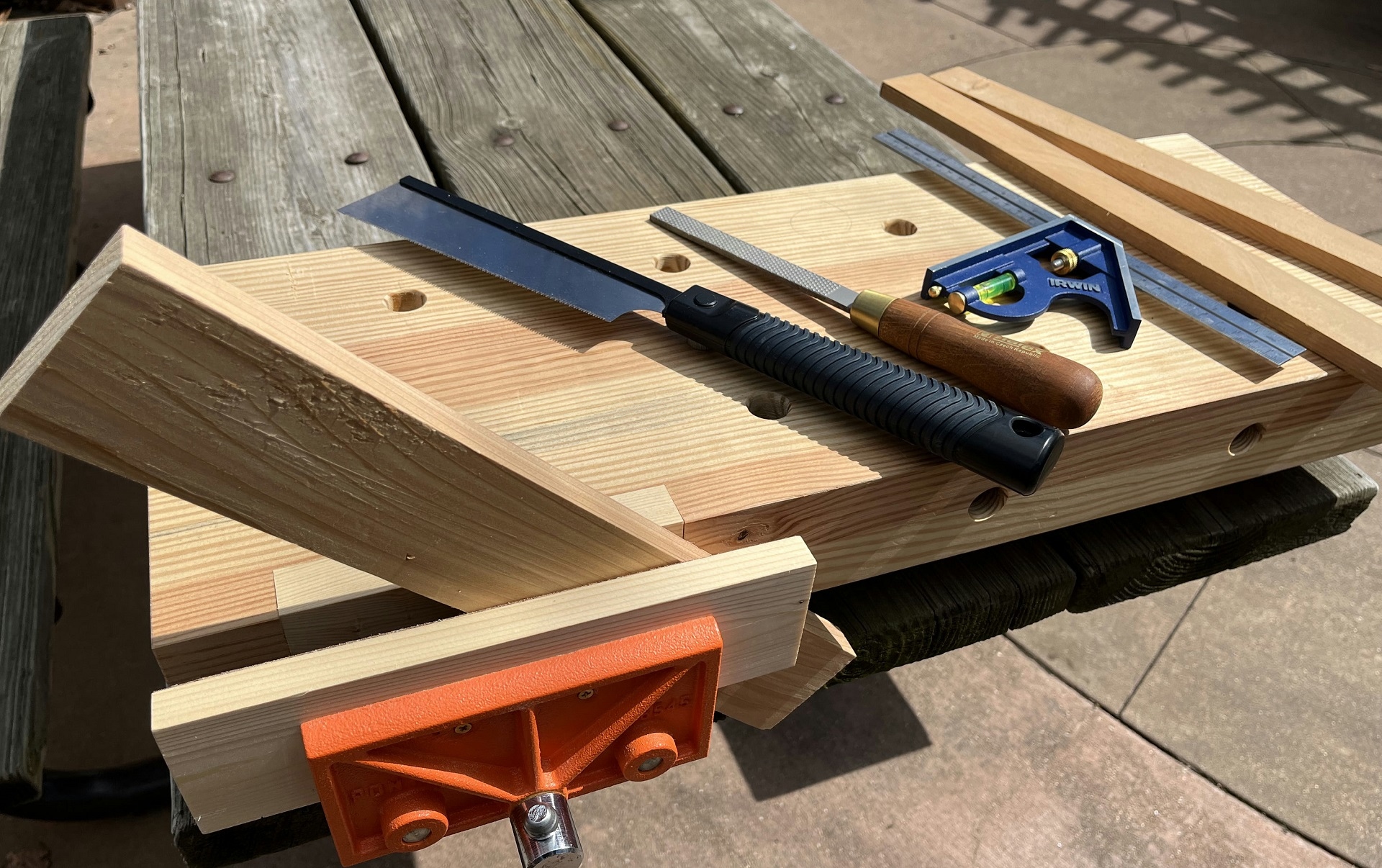 Photograph of woodworking tools laid lout on a wooden bench