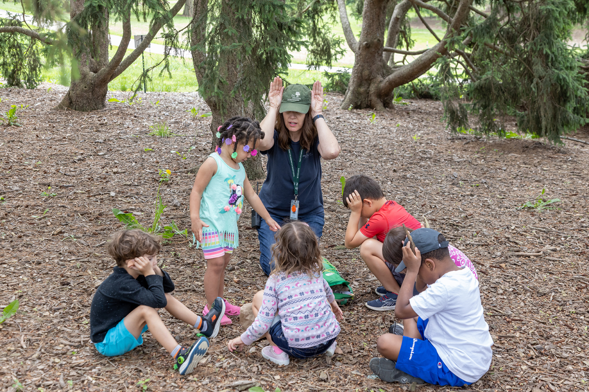 Children gather with an arboretum instructor for an interactive story in the Children's Garden