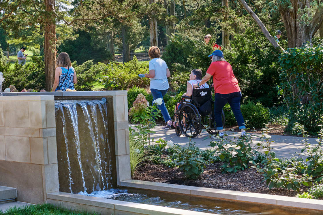 A group of guests enjoy The Gerard T. Donnelly Grand Garden while in a wheelchair