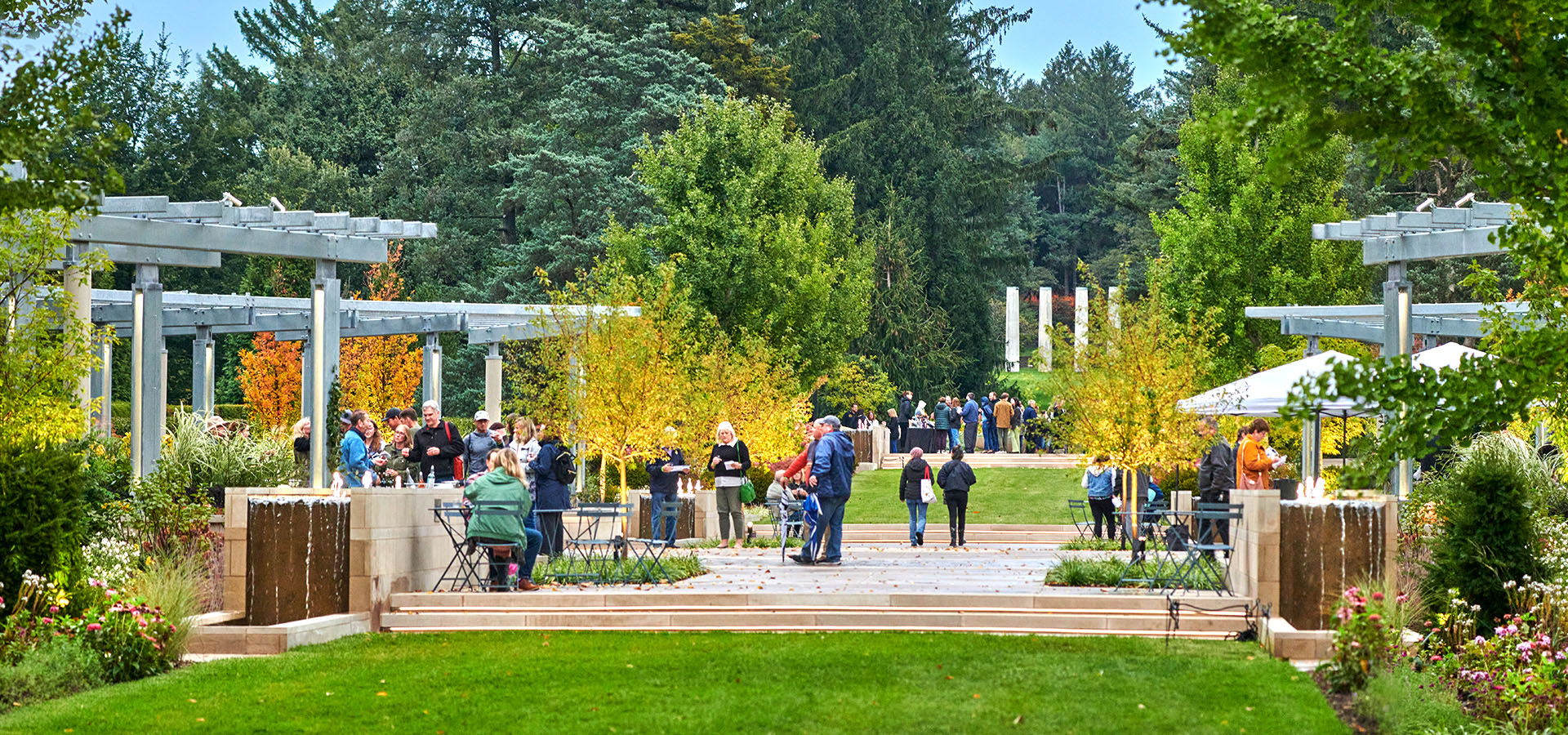 Photograph of visitors and event attendees enjoying wine in The Gerard T Donnelly Grand Garden at the Fall Color Wine Tasting at The Morton Arboretum