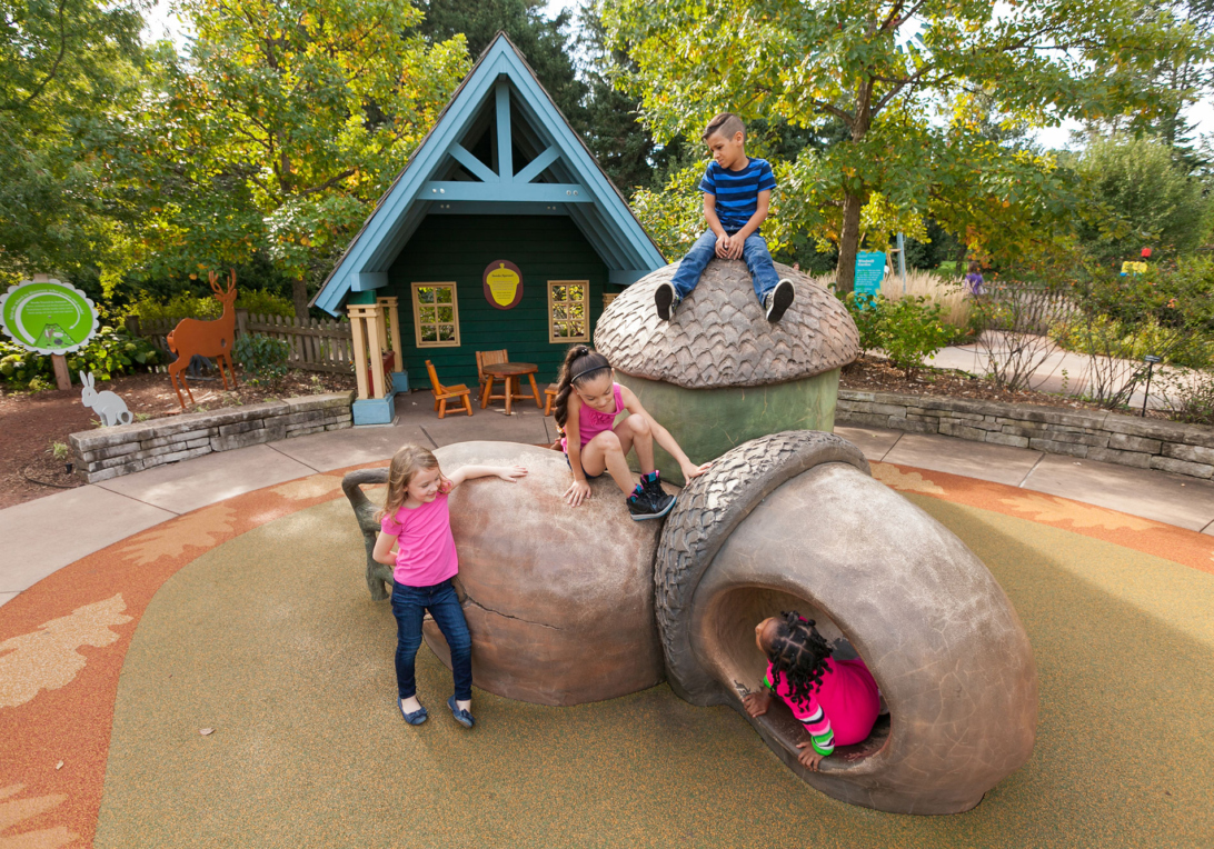 Children climb on large acorn sculptures in the Children's Garden