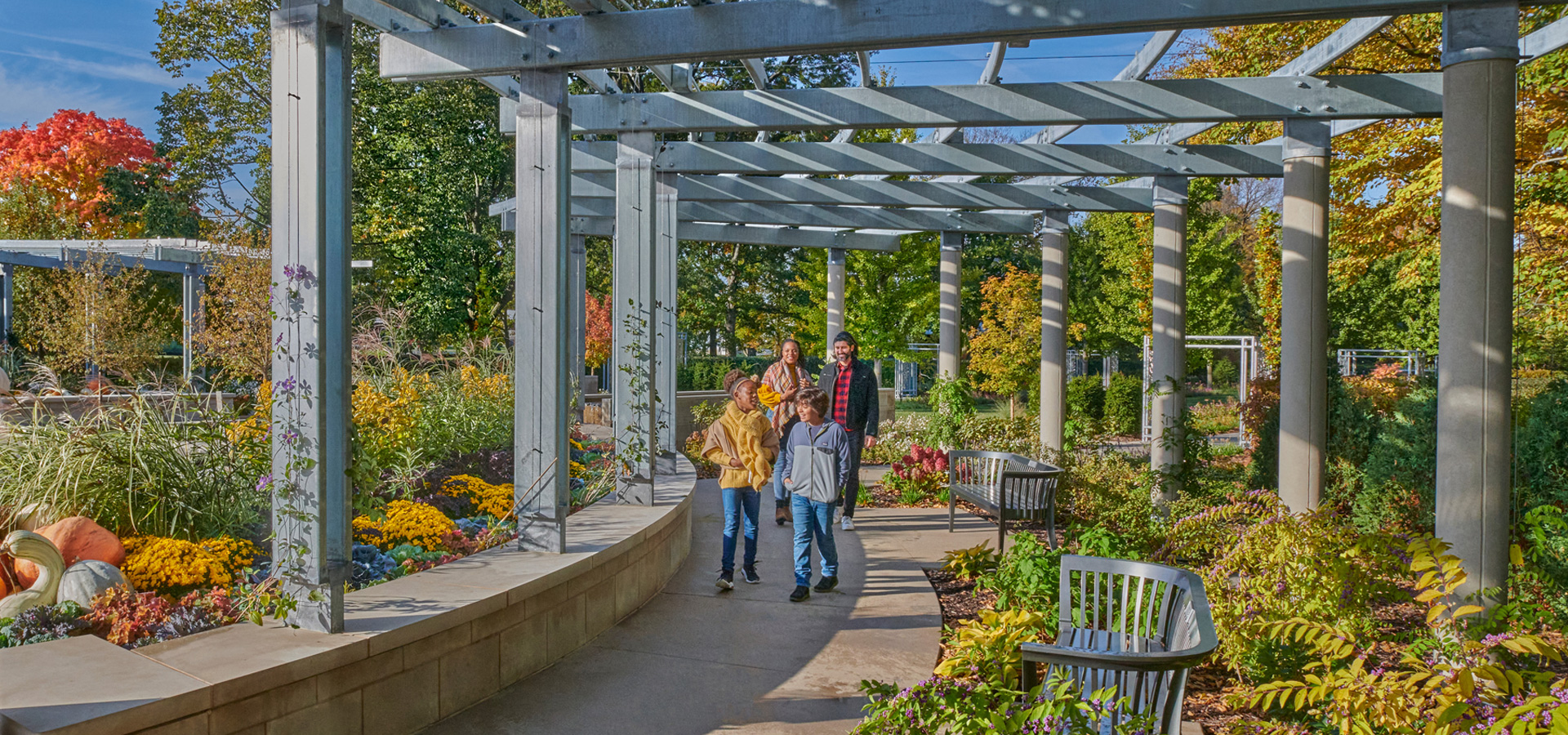 A family walks through the new Grand Garden during fall