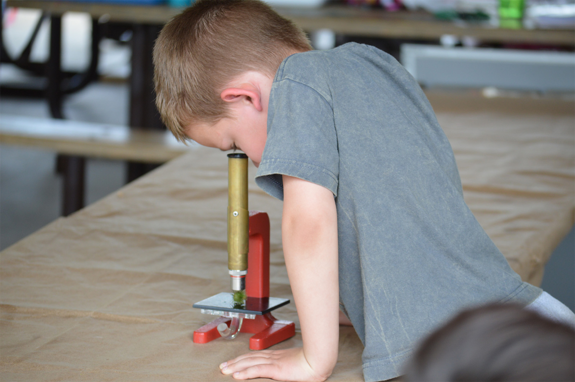 A camp student looking into a microscope