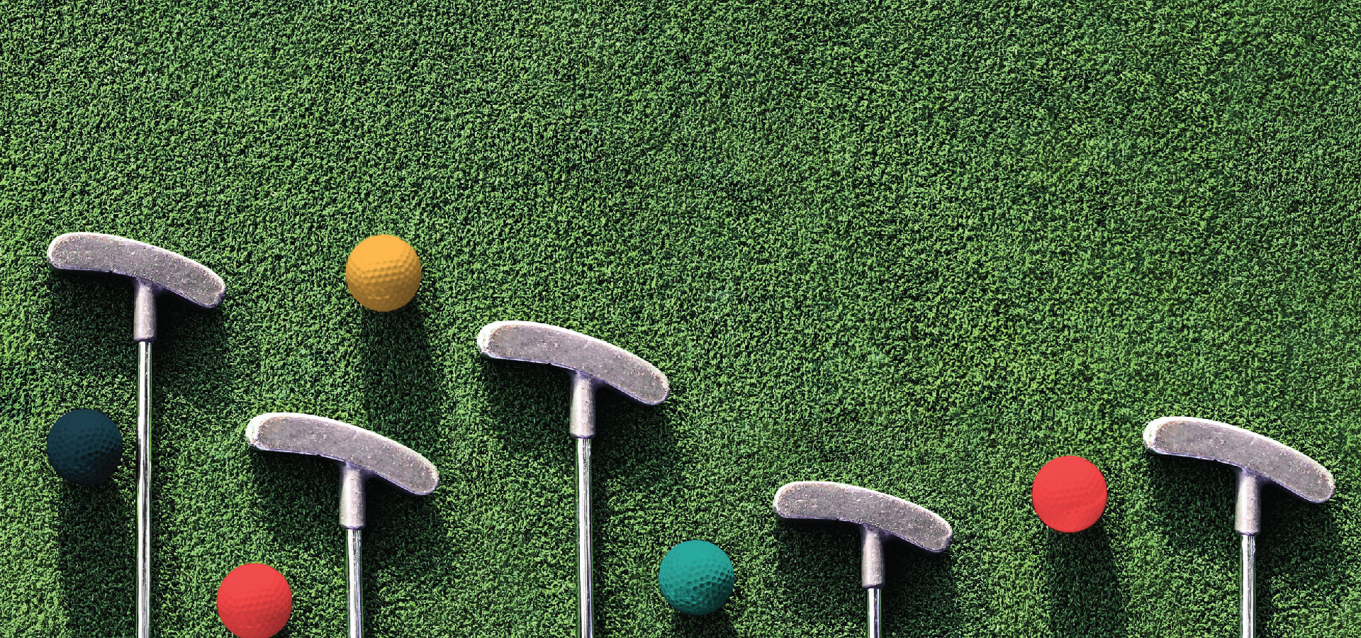 Photograph of mini golf clubs and turf with colored golf balls