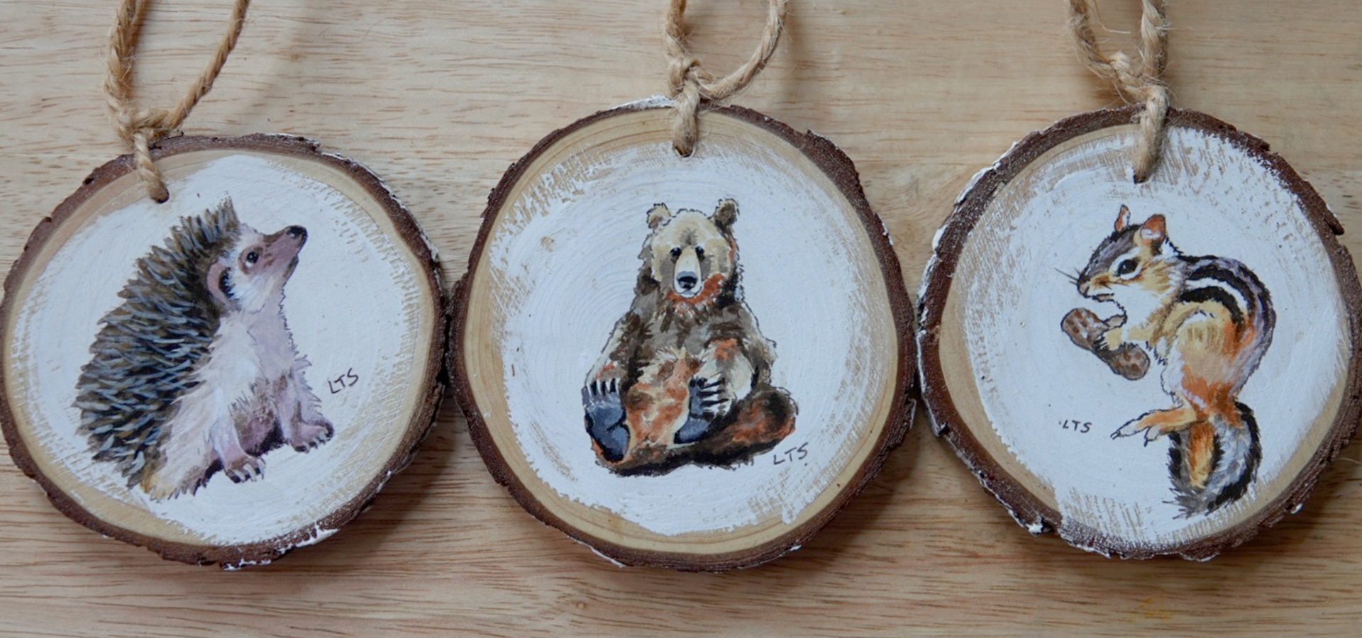 Photograph of three paintings on wooden ornaments of animals