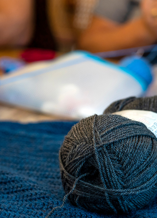 A photograph showing different types of yarn and fiber arts supplies on a work table