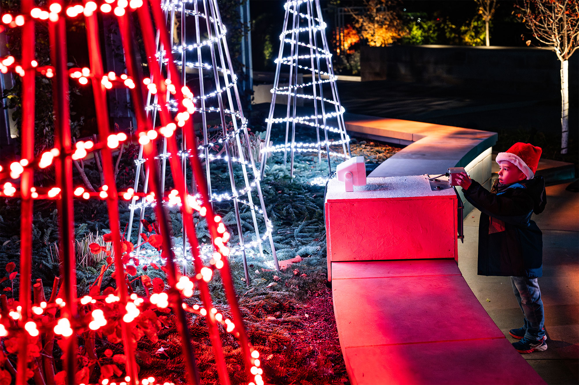 A little boy interacting with one of the light displays on the Illumination trail