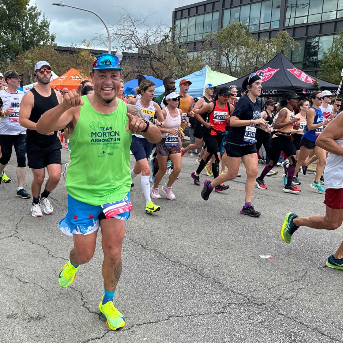 Runner in Team Morton Arboretum tank top pointing at the camera