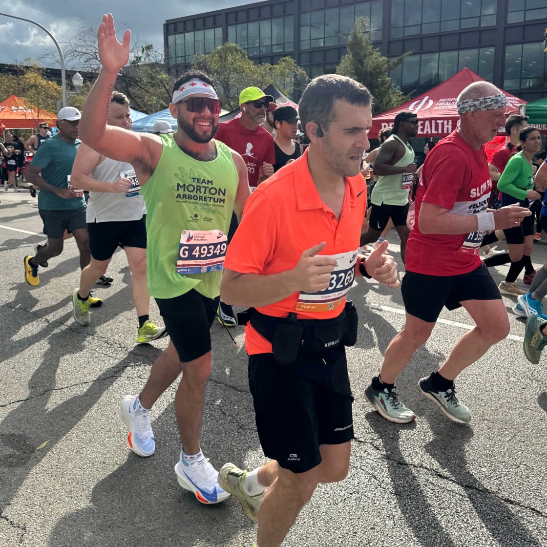 Runner in Team Morton Arboretum tank top waving to the camera