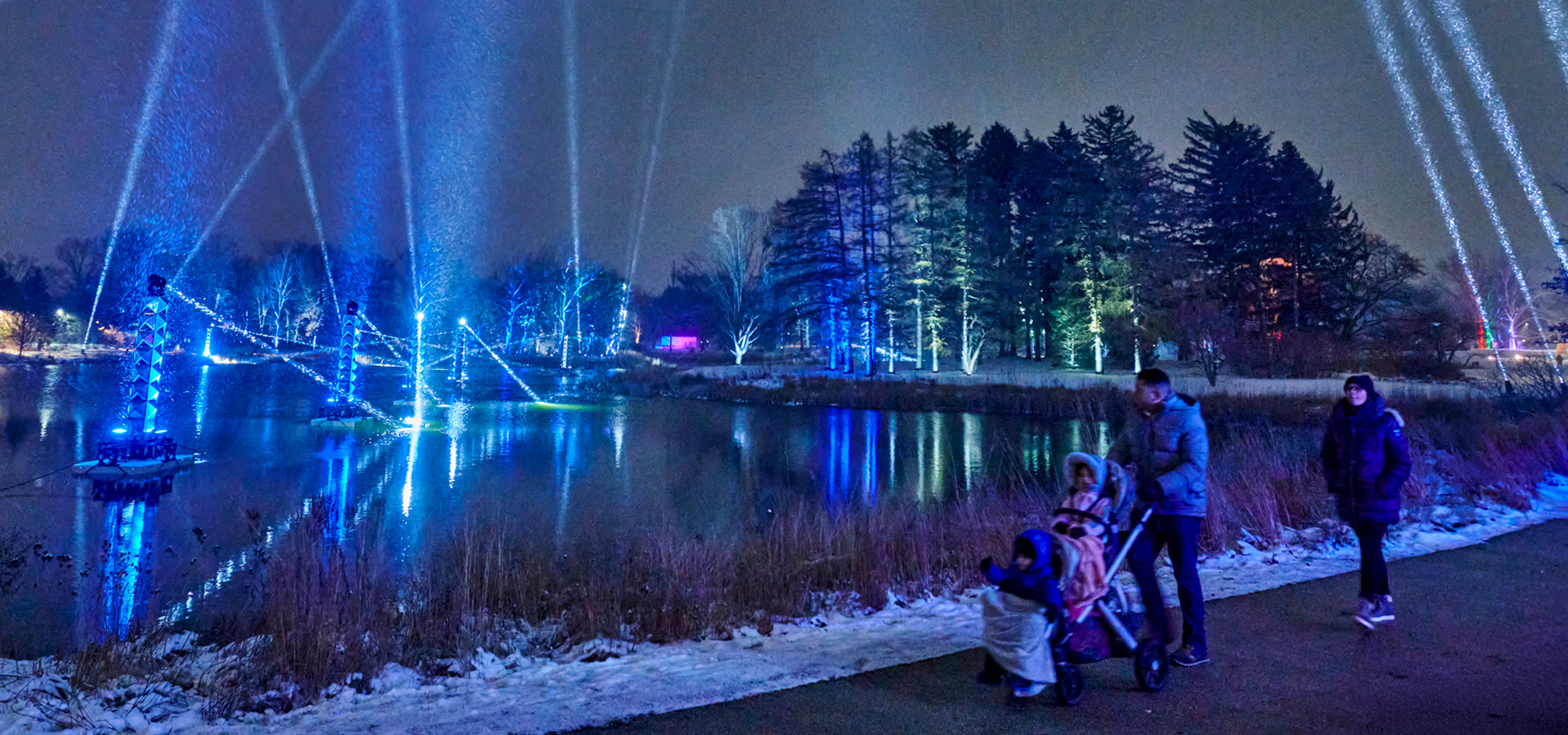 Families enjoying one of the holiday light displays on the Illumination trail around Meadow Lake