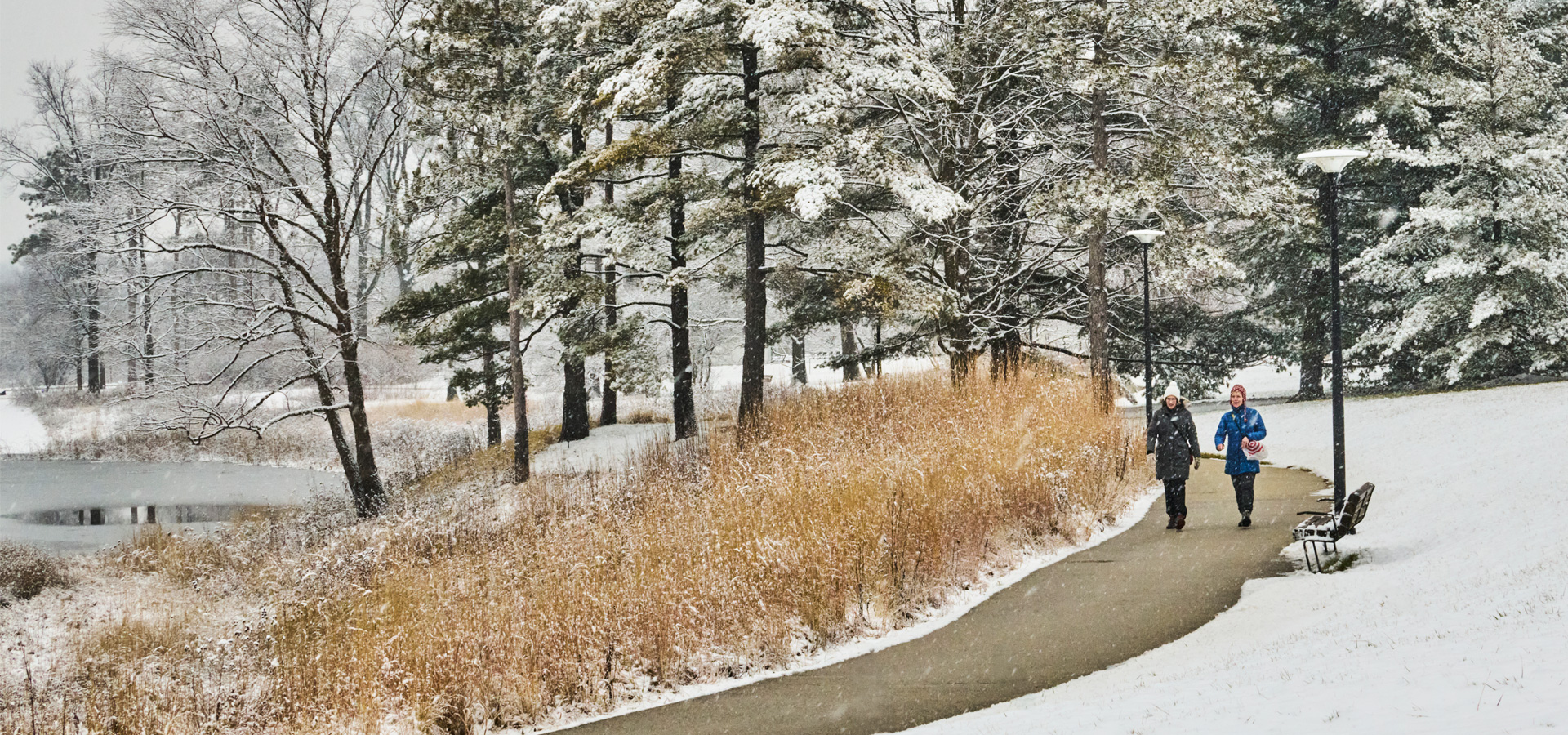 Two guests walking on a snowy day at The Morton Arboretum