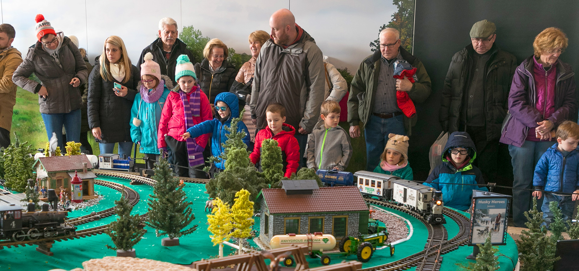 Photograph of a crowd at The Morton Arboretum looking at model train set