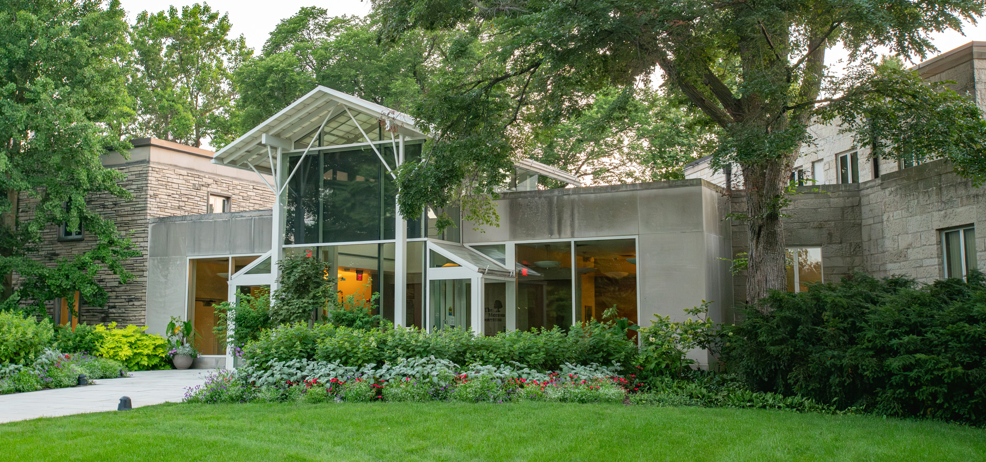 The front of the Administration and Research Center in summer with flowers blooming.