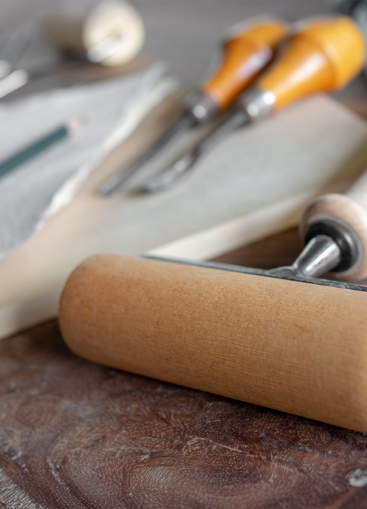 An array of woodcutting tools including carving tools and a roller.