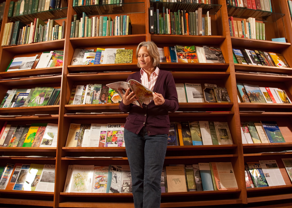 A woman reads a magazine in the Sterling Morton Library.