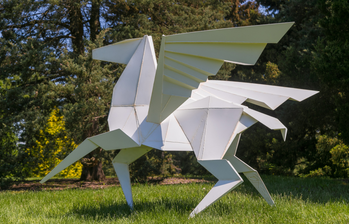 Metal sculpture of a winged horse, faceted and painted white to resemble origami