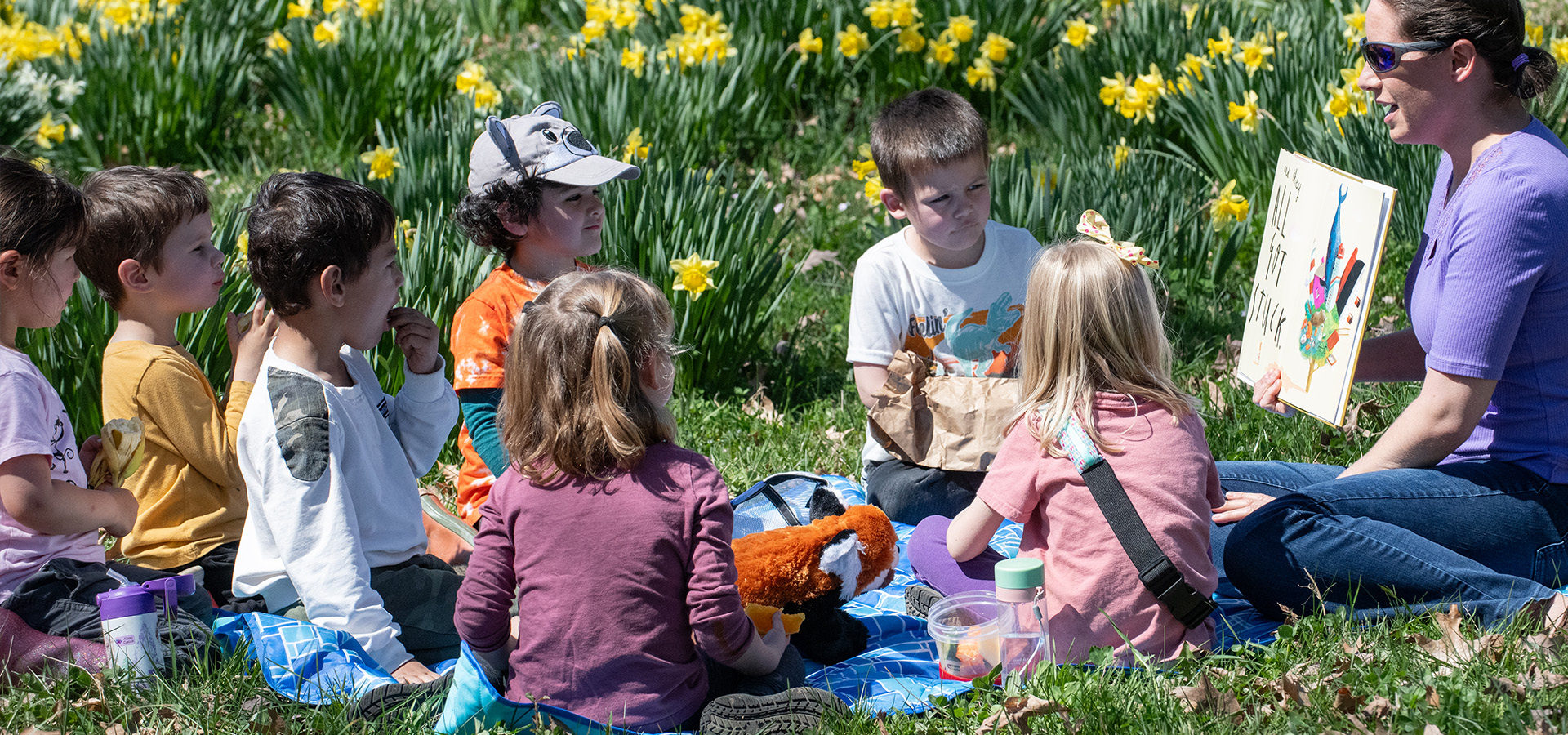 Photograph of an Arboretum instructor reading a childrens book to a group of schoolchildren