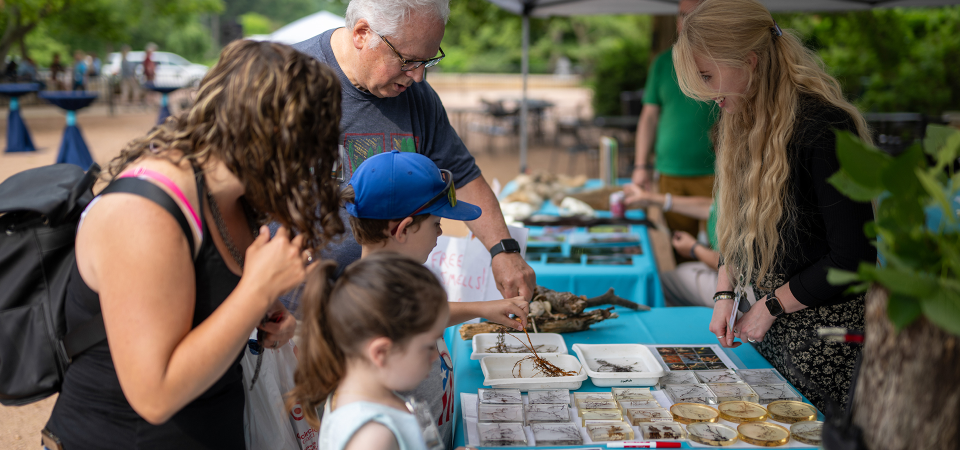 Children and parents interact with science exhibit at a Morton Arboretum event