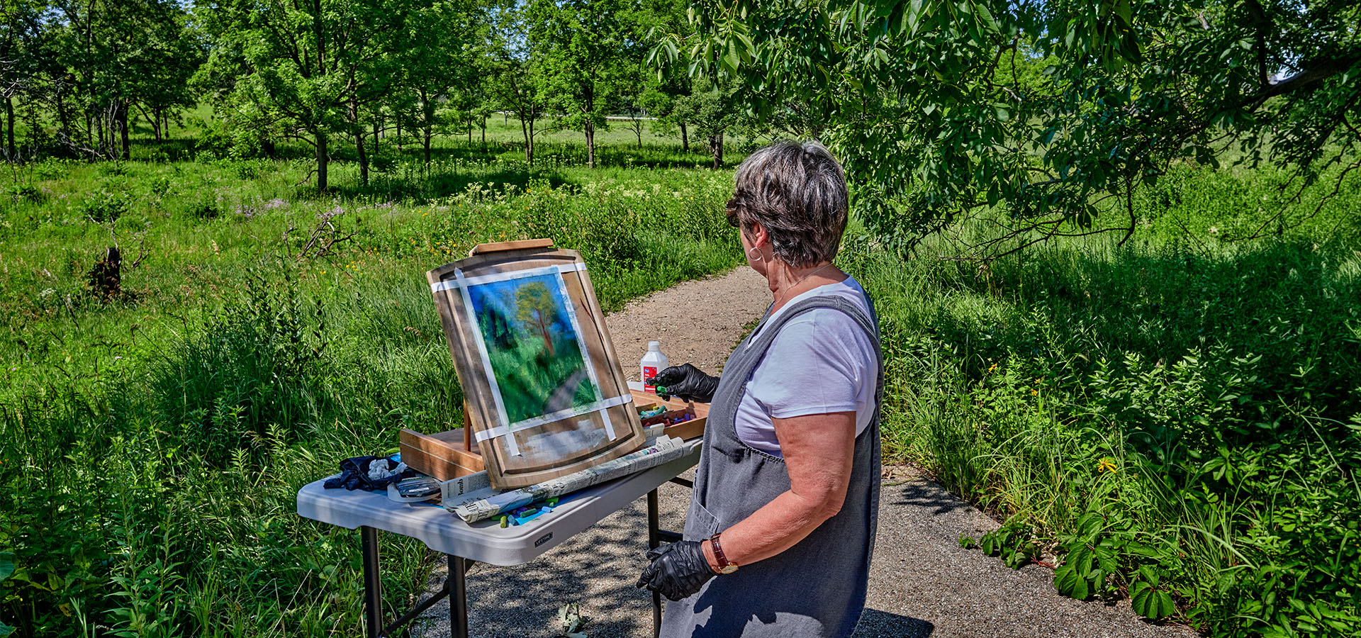 Photograph of an artist painting in plein air at The Morton Arboretum