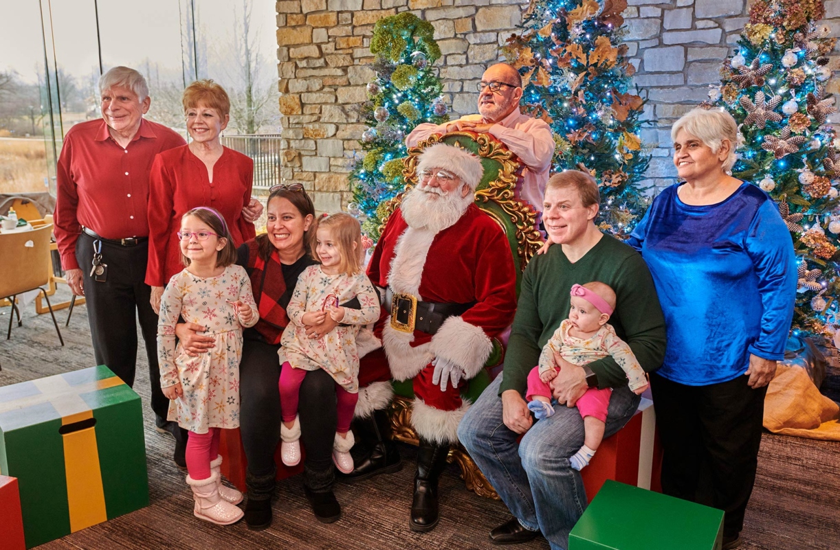 Photograph of a family taking their photo with Santa Claus at a Breakfast with Santa event