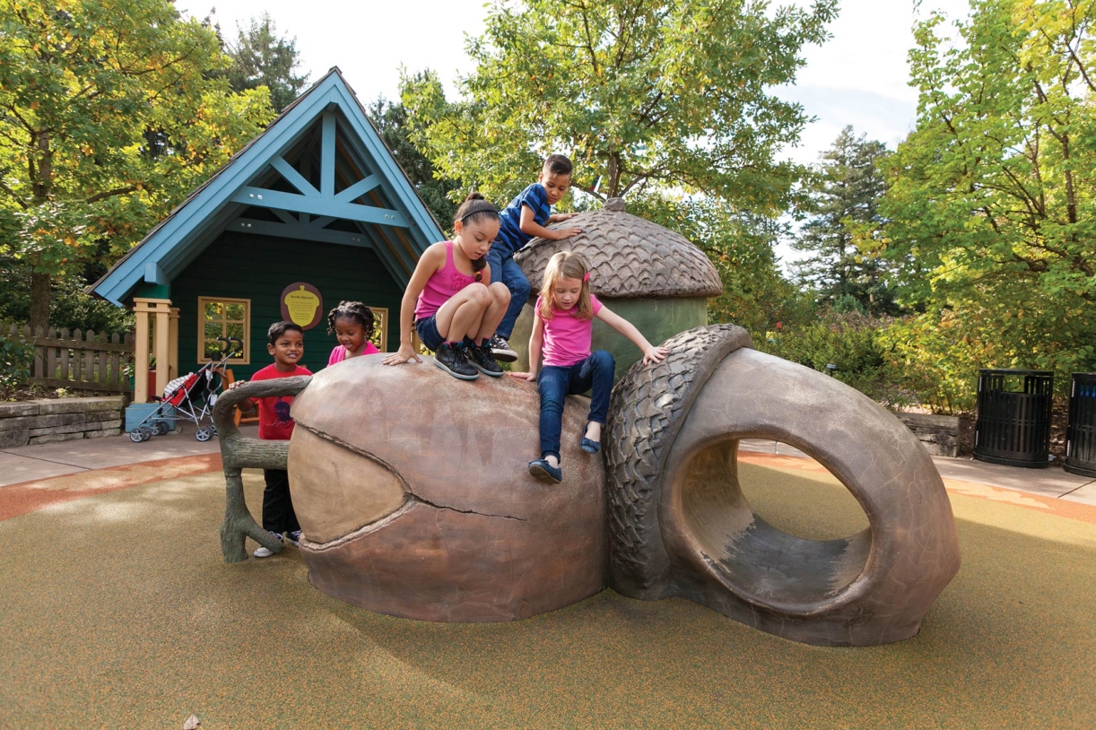 Children climbing on giant acorns at the Children's Garden in The Morton Arboretum